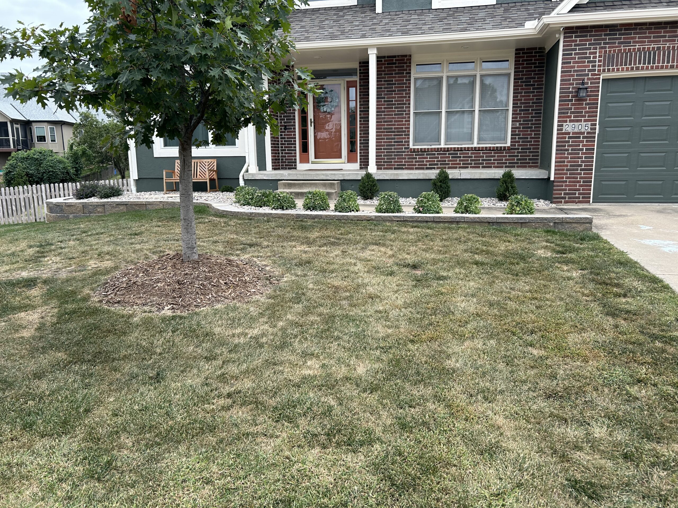 Landscaping in front of brick home